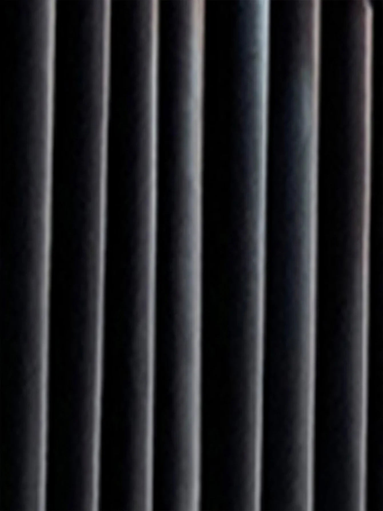 Close-up of black velvet curtain with soft vertical folds, rich texture, and matte finish