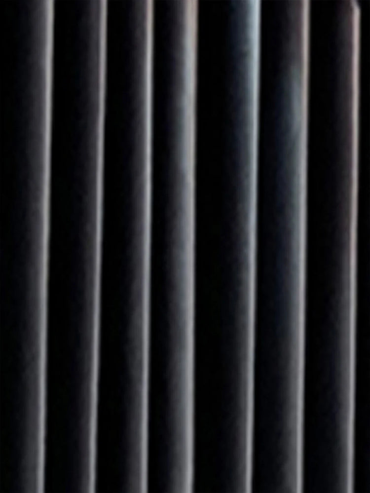 Close-up of black velvet curtain with soft vertical folds, rich texture, and matte finish