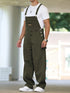 Man wearing loose fit olive green denim overalls and white t-shirt, casual streetwear style