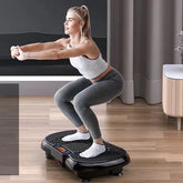 Woman wearing grey leggings and white sports bra, performing squats on a vibration platform in a modern room.