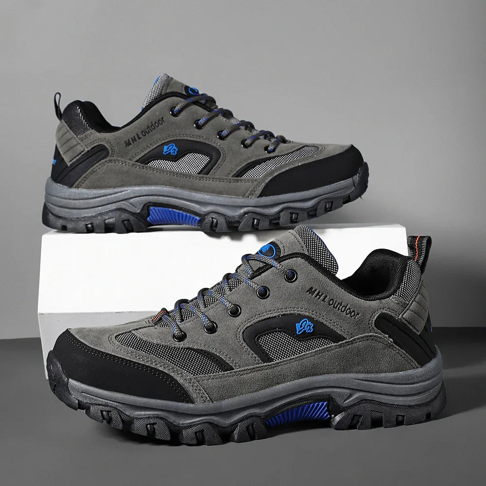 Gray and black mesh hiking sneakers with rugged soles and blue accents, modern outdoor style