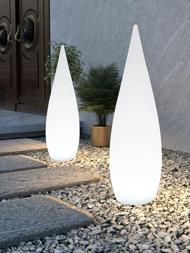 Modern outdoor LED cone lights on stone pathway with plants, minimalist design
