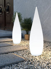 Modern outdoor LED cone lights on stone pathway with plants, minimalist design
