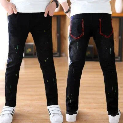 Slim fit black jeans with subtle paint splatter and red stitched back pockets, casual style