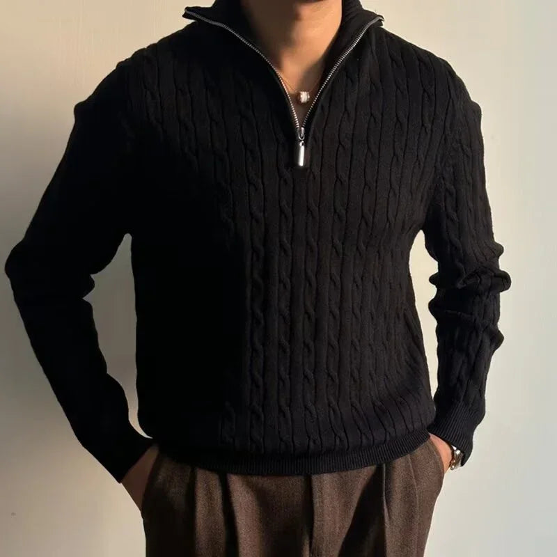 Man wearing a black cable knit half-zip sweater with relaxed fit and textured pattern.