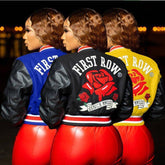 Women wearing blue, black, and yellow graphic varsity jackets with faux leather sleeves and red fitted pants