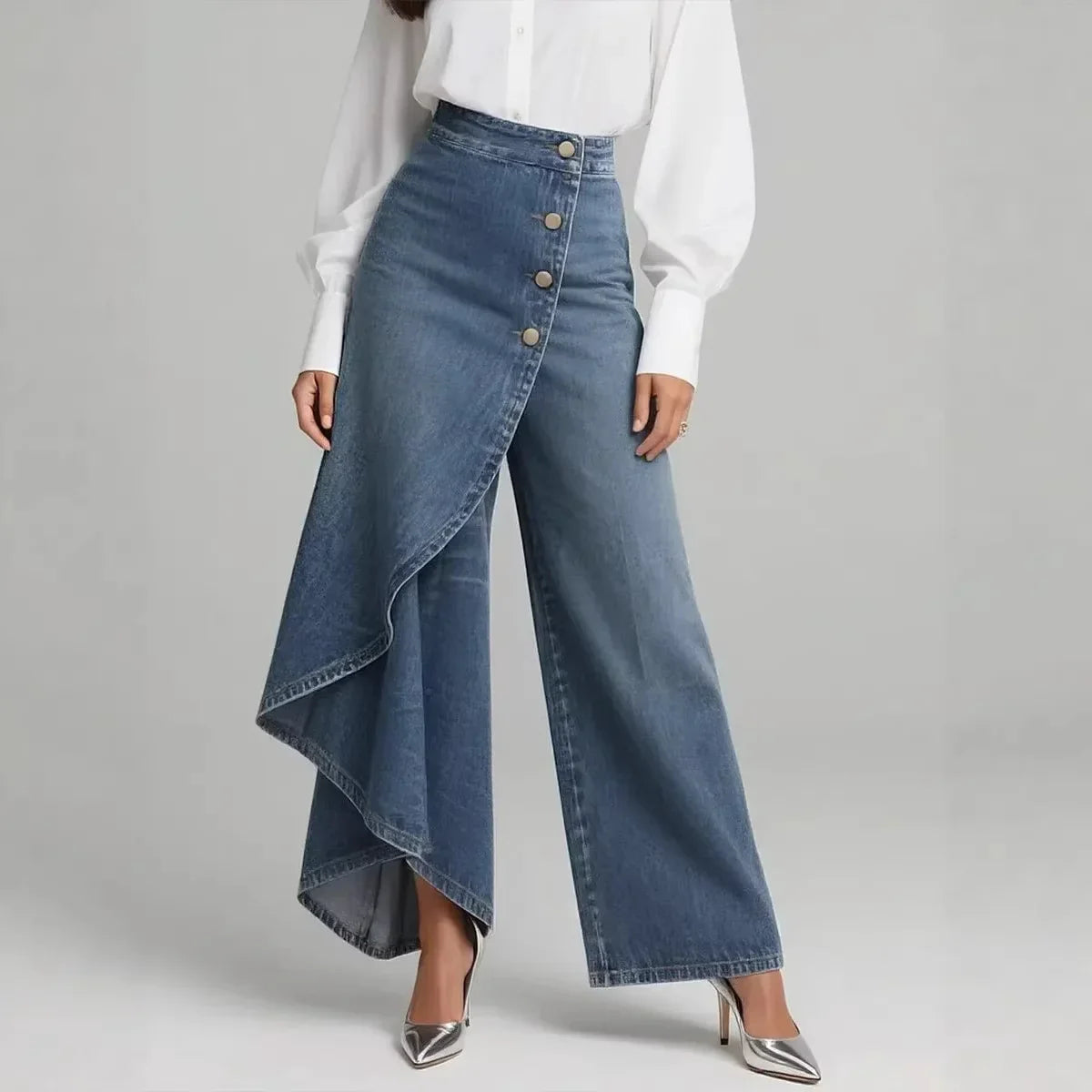 Woman wearing high-waisted, wide-leg blue denim jeans with asymmetric button detail and white blouse