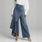 Woman wearing high-waisted, wide-leg blue denim jeans with asymmetric button detail and white blouse