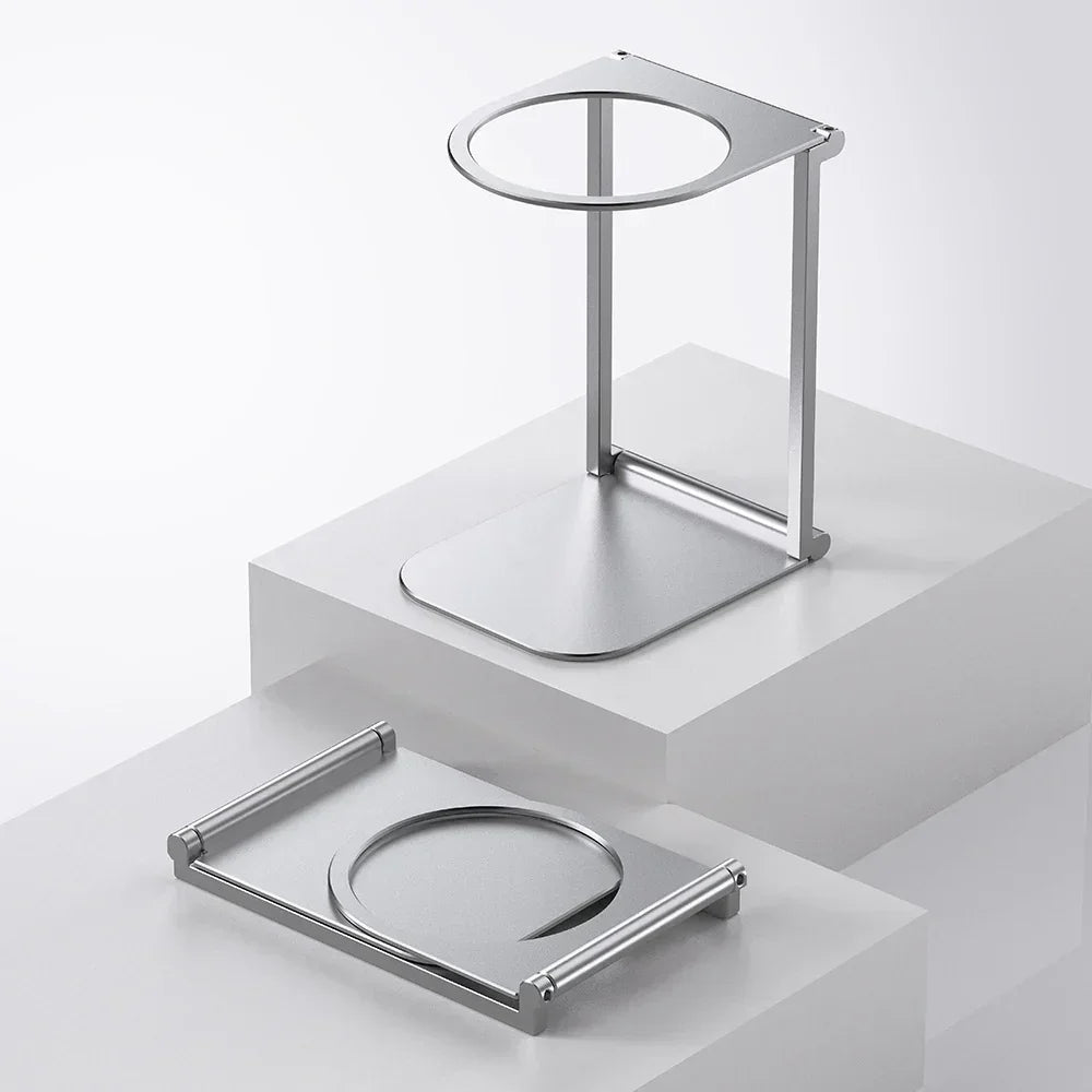 Minimalist silver metal headphone stand with modern geometric design on white display blocks