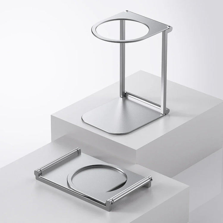 Minimalist silver metal headphone stand with modern geometric design on white display blocks