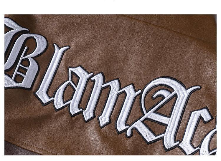 Brown faux leather jacket with bold white embroidered gothic lettering, close-up view