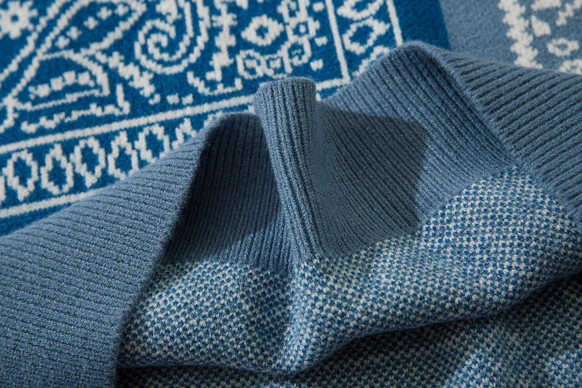 Close-up of blue knit sweater with textured pattern and ribbed collar, soft material
