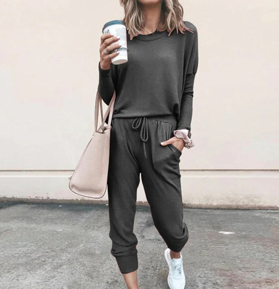 Woman in casual dark gray jogger set with long sleeves, drawstring waist, and relaxed fit