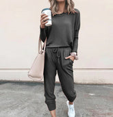 Woman in casual dark gray jogger set with long sleeves, drawstring waist, and relaxed fit