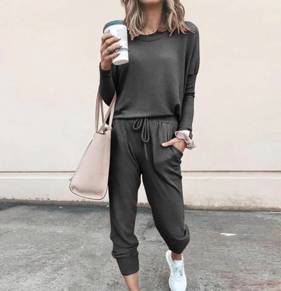 Woman in casual dark gray jogger set with long sleeves, drawstring waist, and relaxed fit
