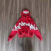 Red zip-up hoodie with bold white graffiti print, relaxed fit, soft cotton material, streetwear style