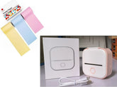 Compact white and pink portable mini printer with USB cable, box, and pastel printer paper rolls.