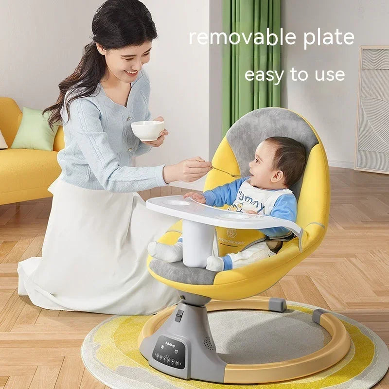 Woman wearing a light blue cardigan and white skirt feeding a baby in a yellow and gray soft baby seat with a removable white feeding tray, showing modern, comfortable lifestyle apparel.