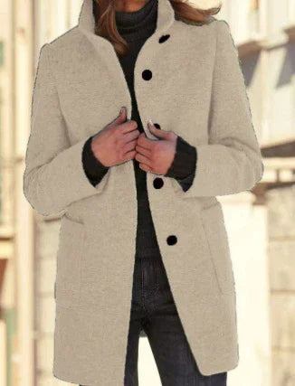 Woman wearing a beige wool blend coat with black buttons, tailored fit, and high collar.