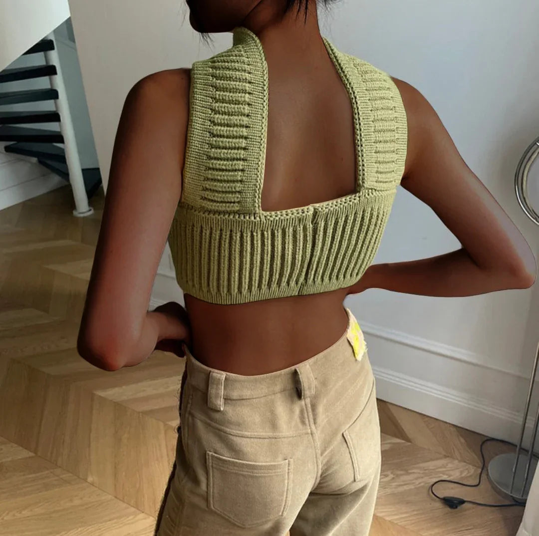 Woman wearing a ribbed knit sage green crop top and high-waisted beige pants, modern fit