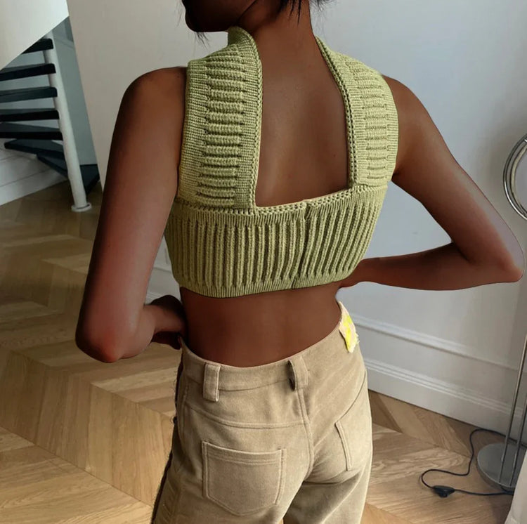 Woman wearing a ribbed knit sage green crop top and high-waisted beige pants, modern fit