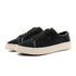 Black suede low-top sneakers with chunky cream rubber soles and lace-up design