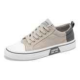 Beige and gray canvas low-top sneaker with lace-up closure and rubber sole, casual fit.