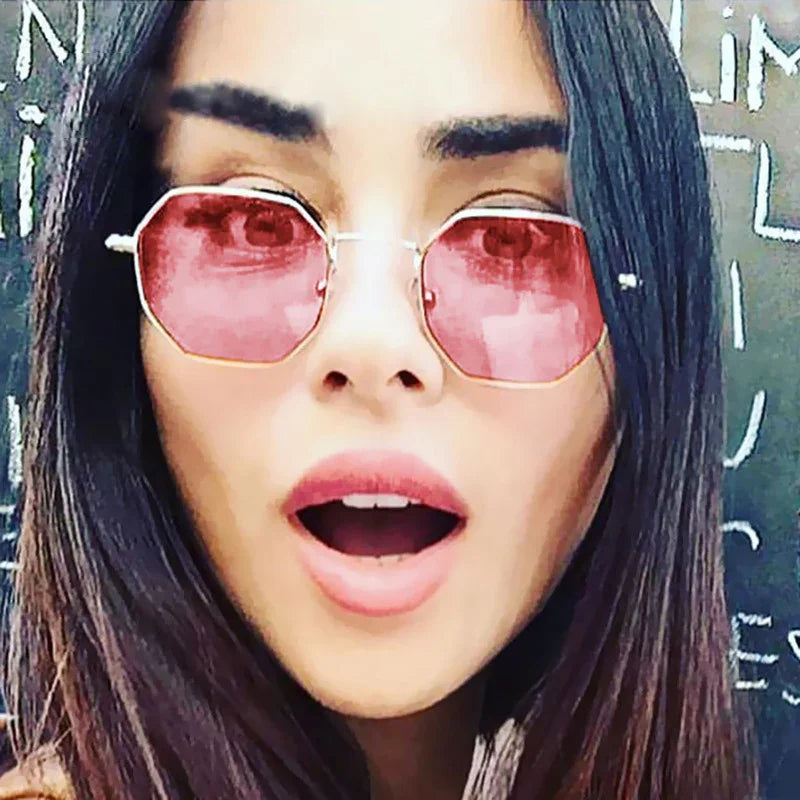 Woman wearing geometric pink tinted sunglasses, straight dark hair, street style look