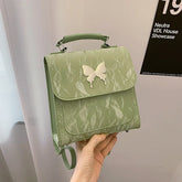 Light green faux leather mini backpack with butterfly appliqué and textured finish
