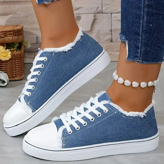 Blue denim low-top sneakers with white rubber soles and frayed edges, casual fit