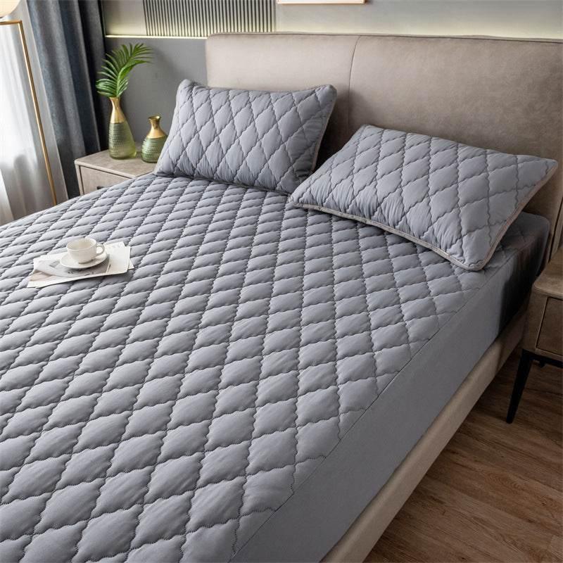 Modern bedroom with light grey quilted bedding set, diamond pattern, and matching pillows