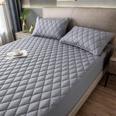 Modern bedroom with light grey quilted bedding set, diamond pattern, and matching pillows