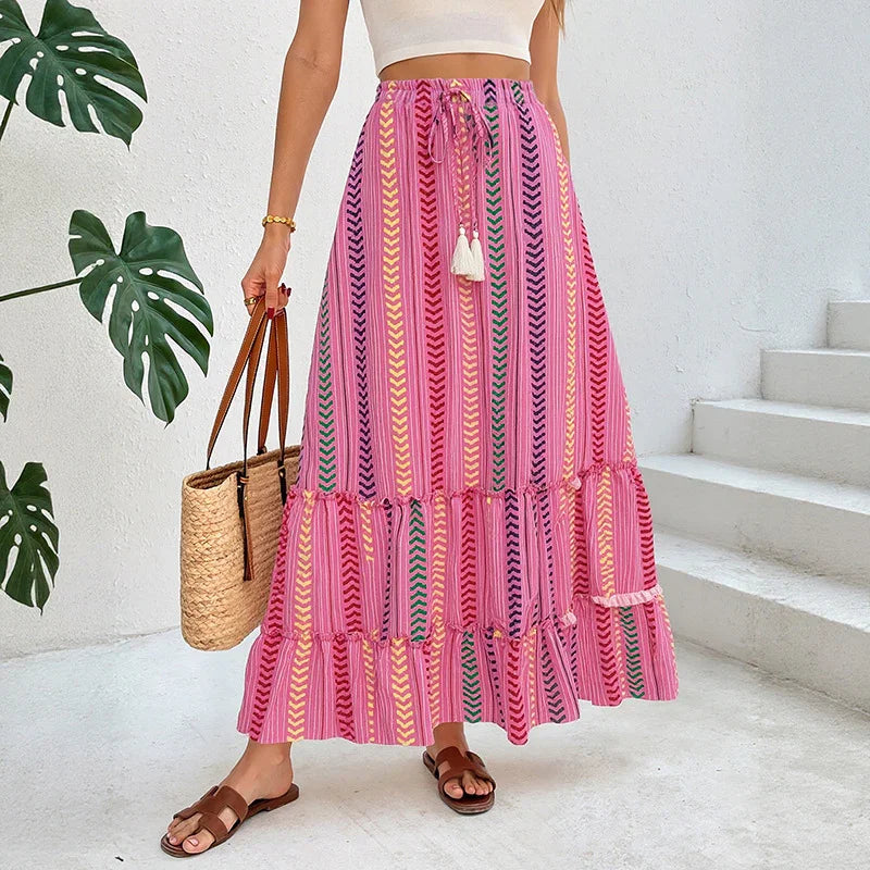 Woman wearing a pink boho maxi skirt with chevron print, flowy fit, paired with a white crop top.