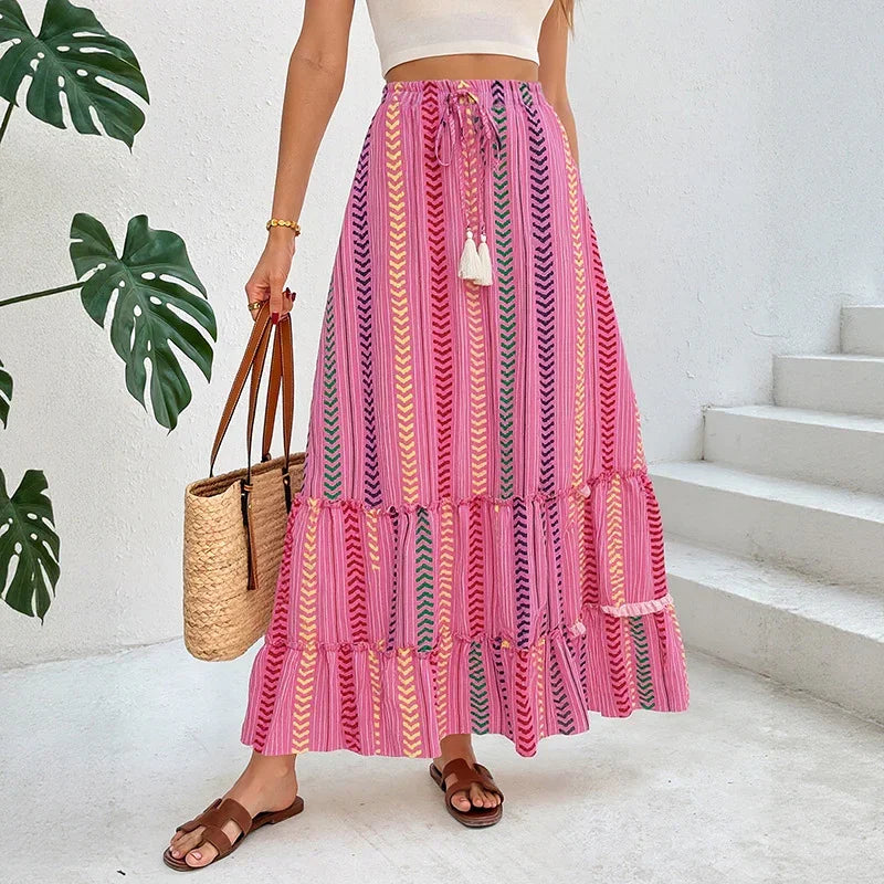 Woman wearing a pink boho maxi skirt with chevron print, flowy fit, paired with a white crop top.