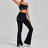 Woman wearing black fitted flare pants and matching crop top with white contrast stitching