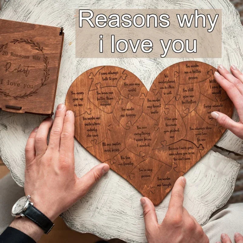 Hands assembling a wooden heart-shaped puzzle with engraved romantic messages on a rustic table.