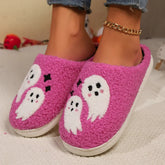 Pink fluffy slippers with white ghost pattern, cozy fit, worn with jeans.