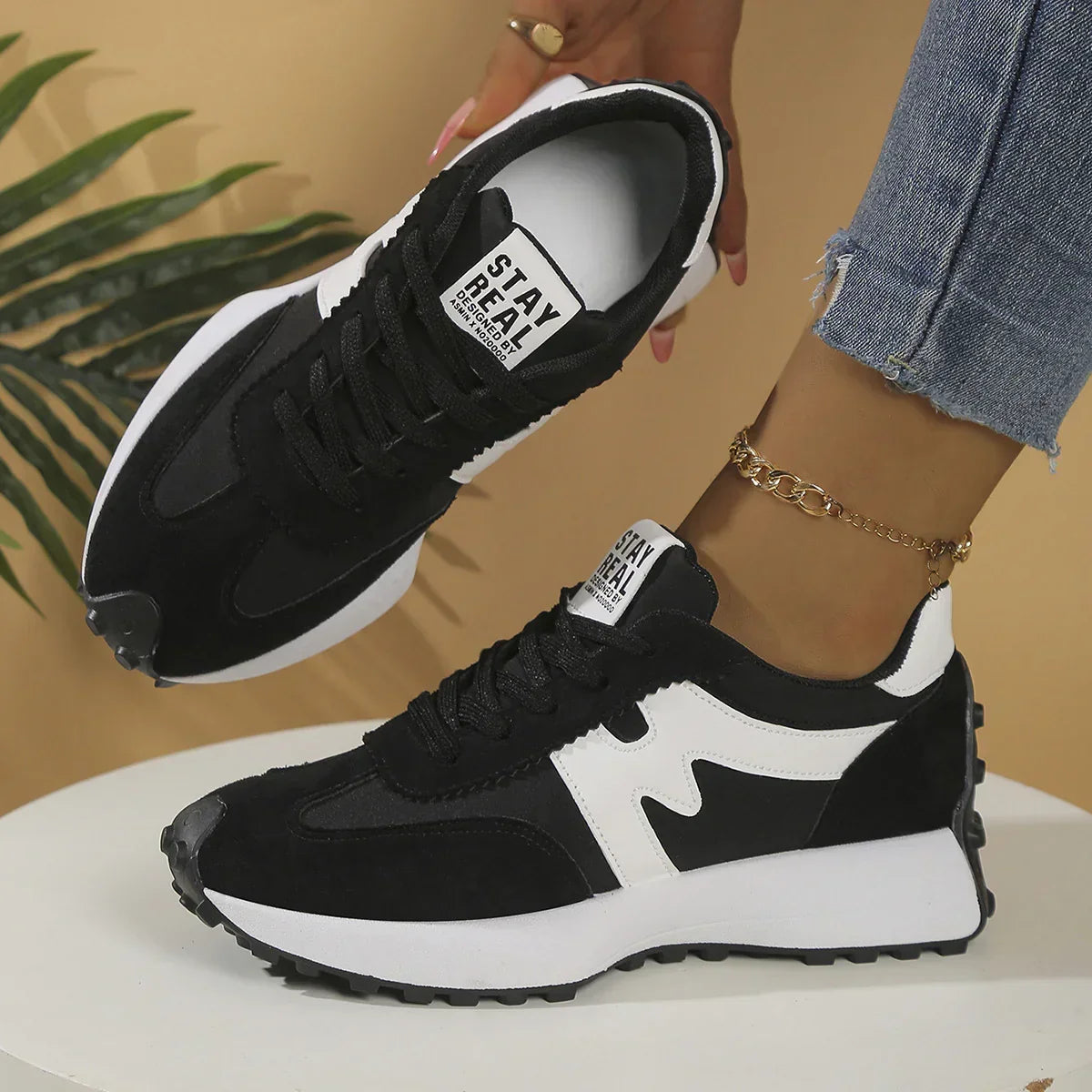 Black and white suede low-top sneakers with chunky sole and wavy side detail, casual fit