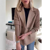Woman wearing a camel double-breasted blazer with ribbed knit sleeves and relaxed fit