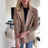 Woman wearing a camel double-breasted blazer with ribbed knit sleeves and relaxed fit