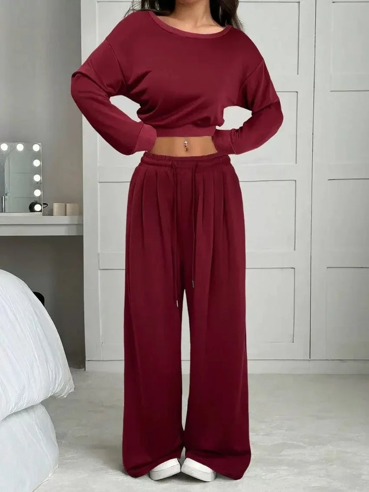 Woman wearing burgundy crop sweatshirt and loose wide-leg lounge pants in soft fabric