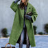 Woman wearing oversized green wool coat, gray sweater, and distressed jeans, street style