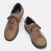 Brown suede low-top sneakers with black soles and brown laces, casual streetwear style