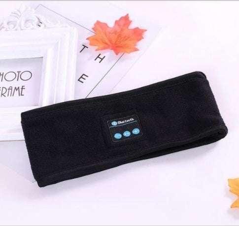 Black fleece Bluetooth headband with control panel, laid flat on white background.