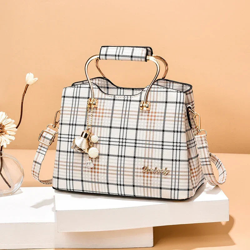Plaid tote handbag with gold handles, detachable strap, and decorative keychain, beige tones