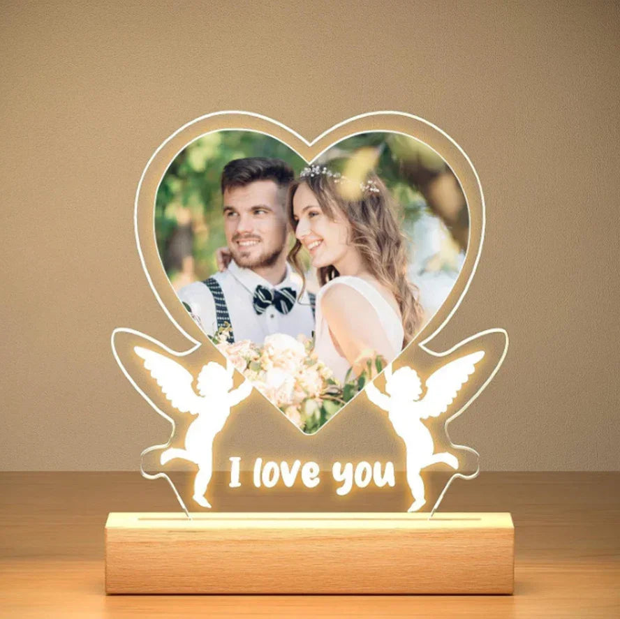 Heart-shaped LED acrylic lamp with custom photo, wooden base, angel silhouettes, 'I love you' text.