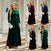 Woman wearing long-sleeve velvet maxi dress with belted waist in green, burgundy, blue, and black, fitted silhouette, elegant evening wear.