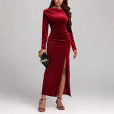 Woman in fitted red velvet long sleeve maxi dress with side slit, elegant evening wear