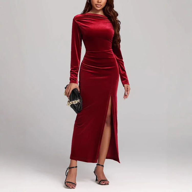Woman in fitted red velvet long sleeve maxi dress with side slit, elegant evening wear