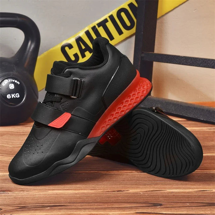 Black athletic sneakers with red textured soles, synthetic material, secure velcro straps, modern streetwear style